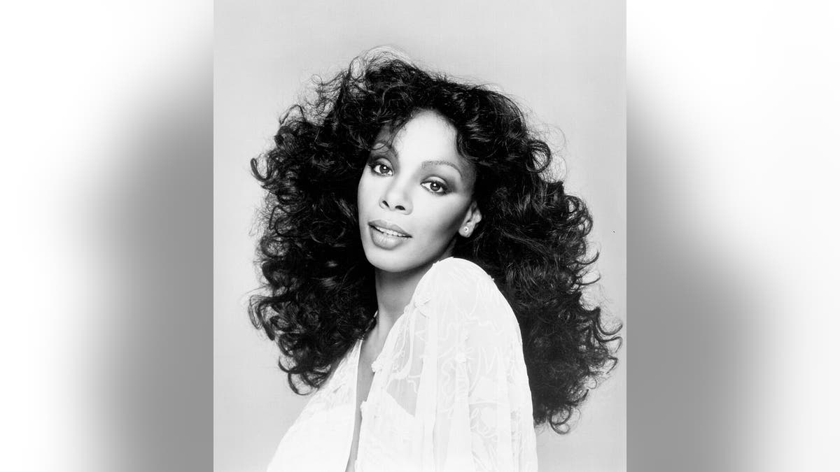 Een zwart-wit foto van donna summer in een witte jurk