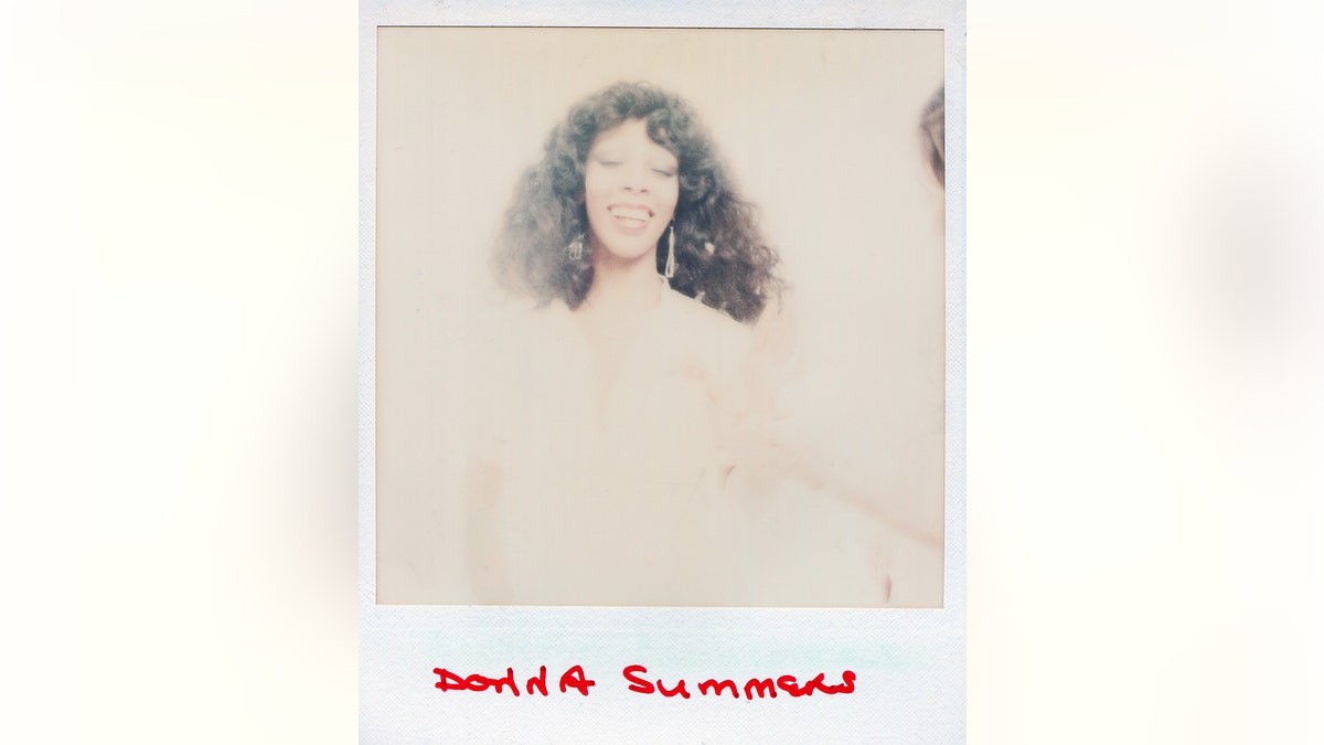 Een polaroid van Donna Summer glimlachend in een wazige achtergrond