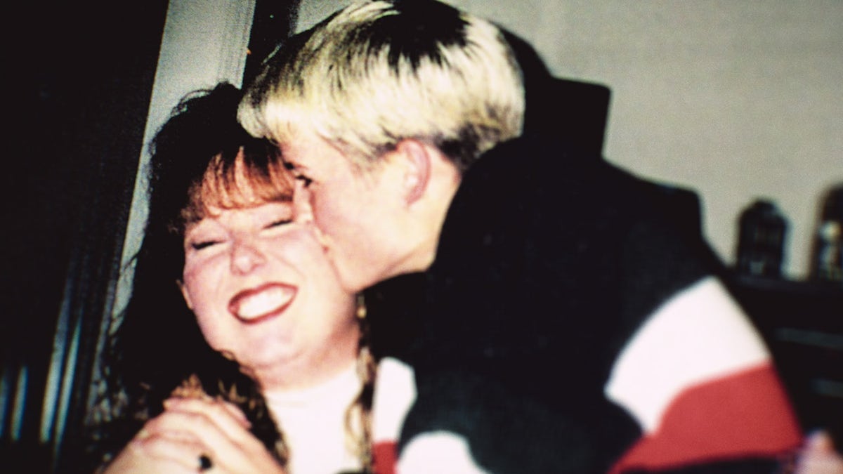 Amy Bradley kust een lachende vrouw op de wang.
