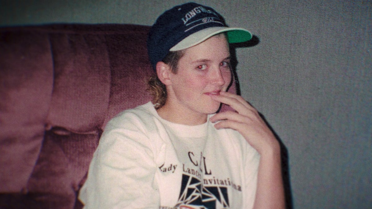 Amy Bradley draagt een wit shirt met zwarte opdruk en een pet.