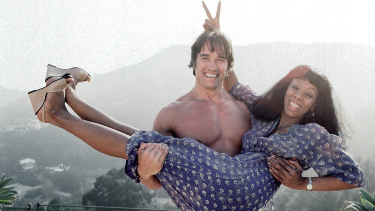 Arnold Schwarzenegger houdt Donna Summer omhoog