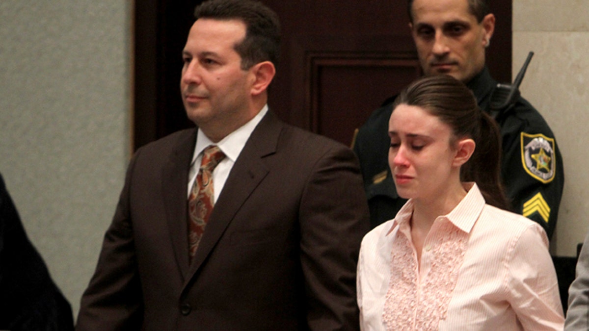 Casey Anthony houdt handen vast met haar advocaten Jose Baez, links, en Dorothy Clay Sims, terwijl ze luisteren naar de uitspraak in het Orange County gerechtsgebouw in Orlando, Fla., dinsdag 5 juli 2011. De jury heeft Anthony vrijgesproken van de moord op haar dochter Caylee. (AP Photo/Red Huber, Pool)