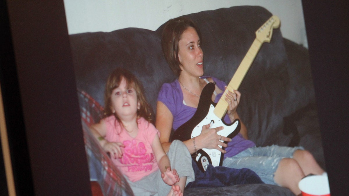Caylee Anthony zit naast haar moeder Casey Anthony en speelt gitaar