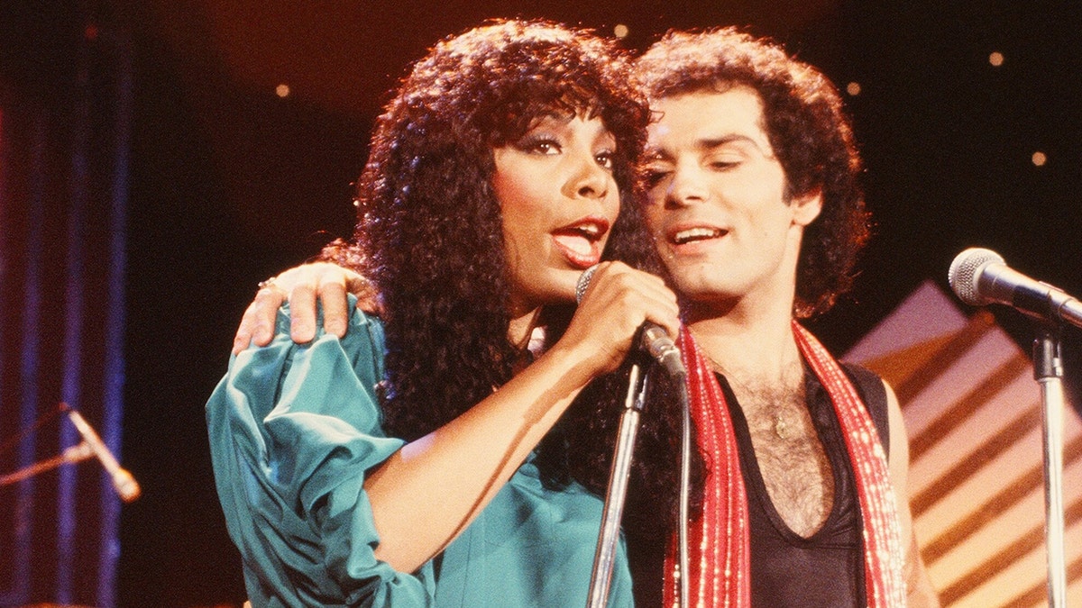 Donna Summer in een groene jurk zingend naast Bruce Sudano
