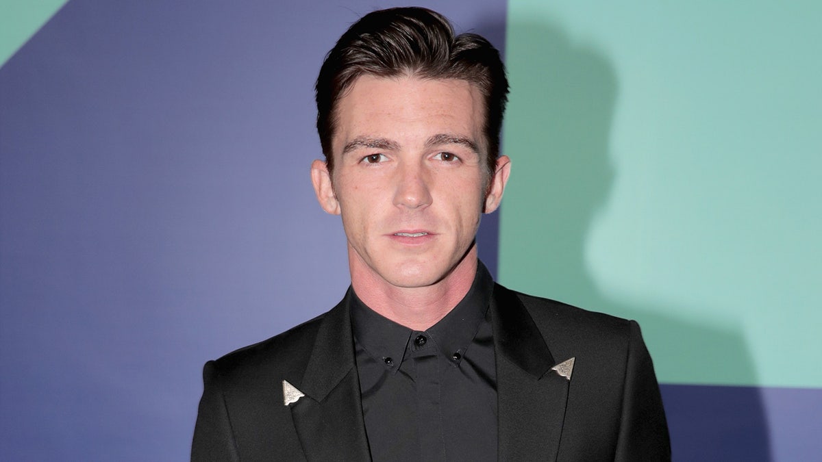 Drake Bell poseert voor de camera's op een rode loper evenement.