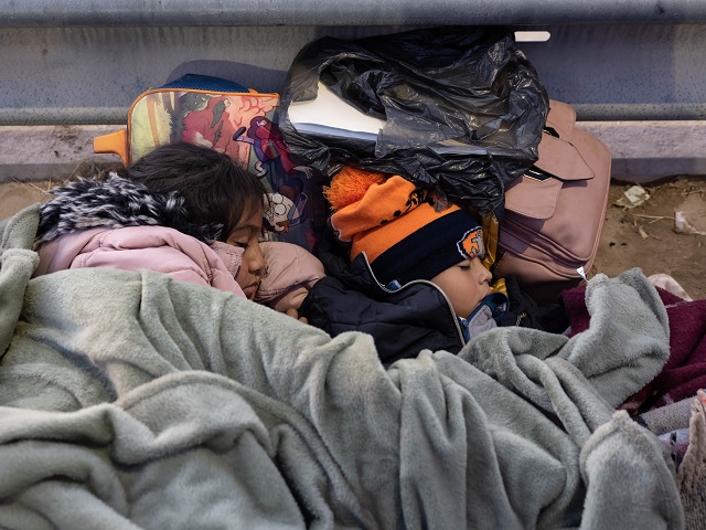 EL PASO, TEXAS - DECEMBER 22: Kinderen uit Colombia slapen terwijl ze met hun familie overnachten langs het grenshek tussen de VS en Mexico op 22 december 2022 in El Paso, Texas. Een piek in het aantal migranten dat asiel zoekt in de Verenigde Staten heeft de lokale, staats- en federale autoriteiten op de proef gesteld. Er wordt verwacht dat de aantallen zullen toenemen nu het lot van de bevoegdheid onder titel 42 om migranten uit te zetten in het ongewisse blijft in afwachting van een beslissing van het Hooggerechtshof die na Kerstmis wordt verwacht. (Foto door John Moore/Getty Images)