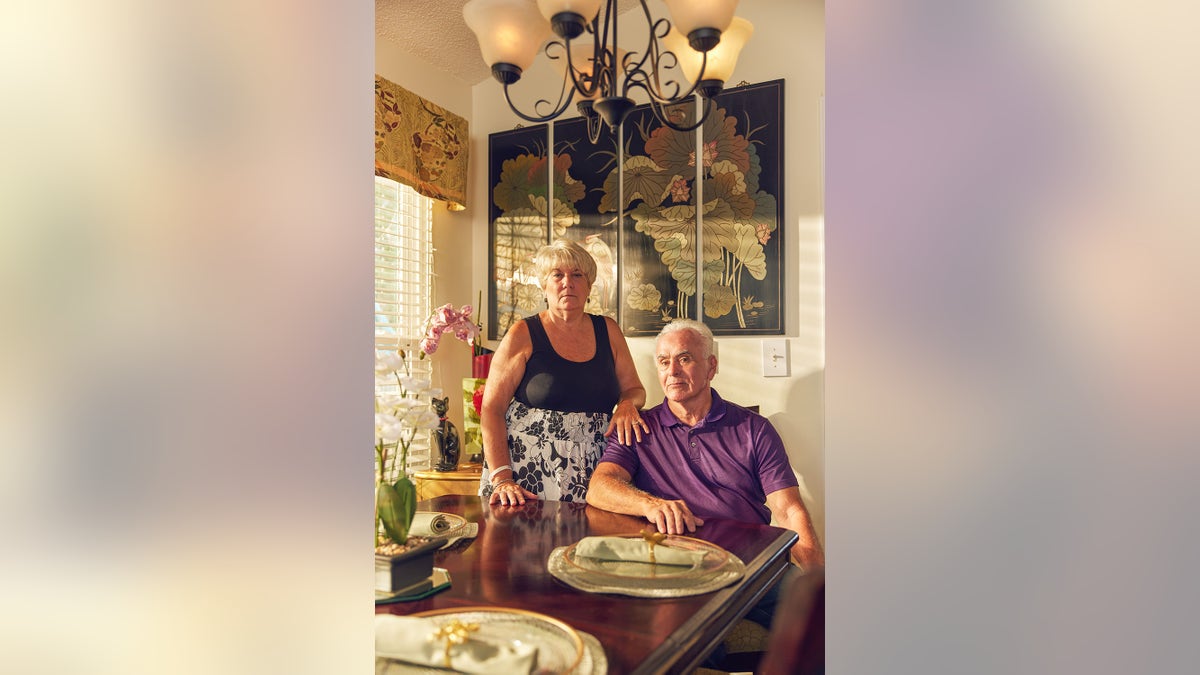 George Anthony zit in een verlichte woonkamer met Cindy Anthony die haar hand op zijn schouder legt