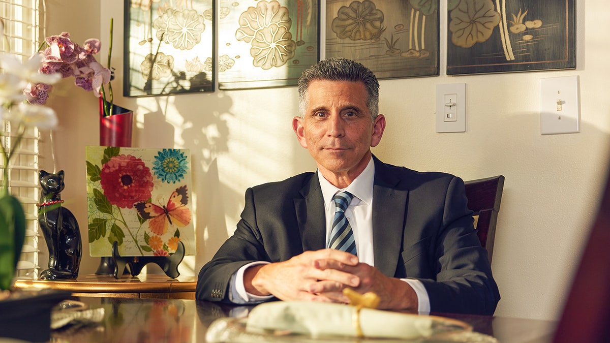George Olivo in pak en zittend