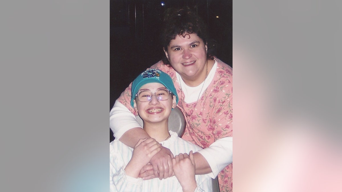 Gypsy Blanchard (links) in een rolstoel en Dee Dee Blanchard (rechts) met haar armen om Gypsy heen