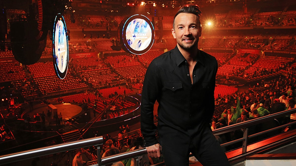 Pastor Carl Lentz van de Hillsong Church staat boven de gemeente in New York