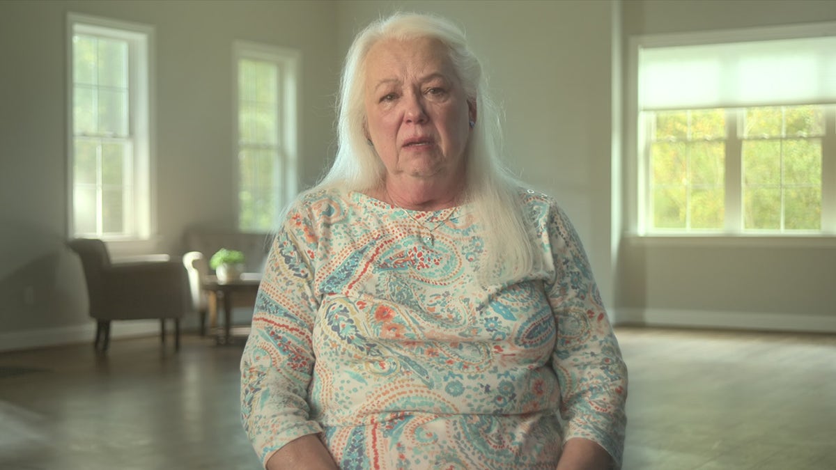 Iva Bradley draagt een witte trui met meerdere prints.