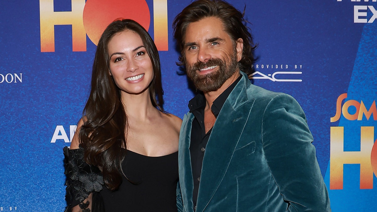 John Stamos draagt fluwelen pak op rode loper met vrouw Caitlin McHugh