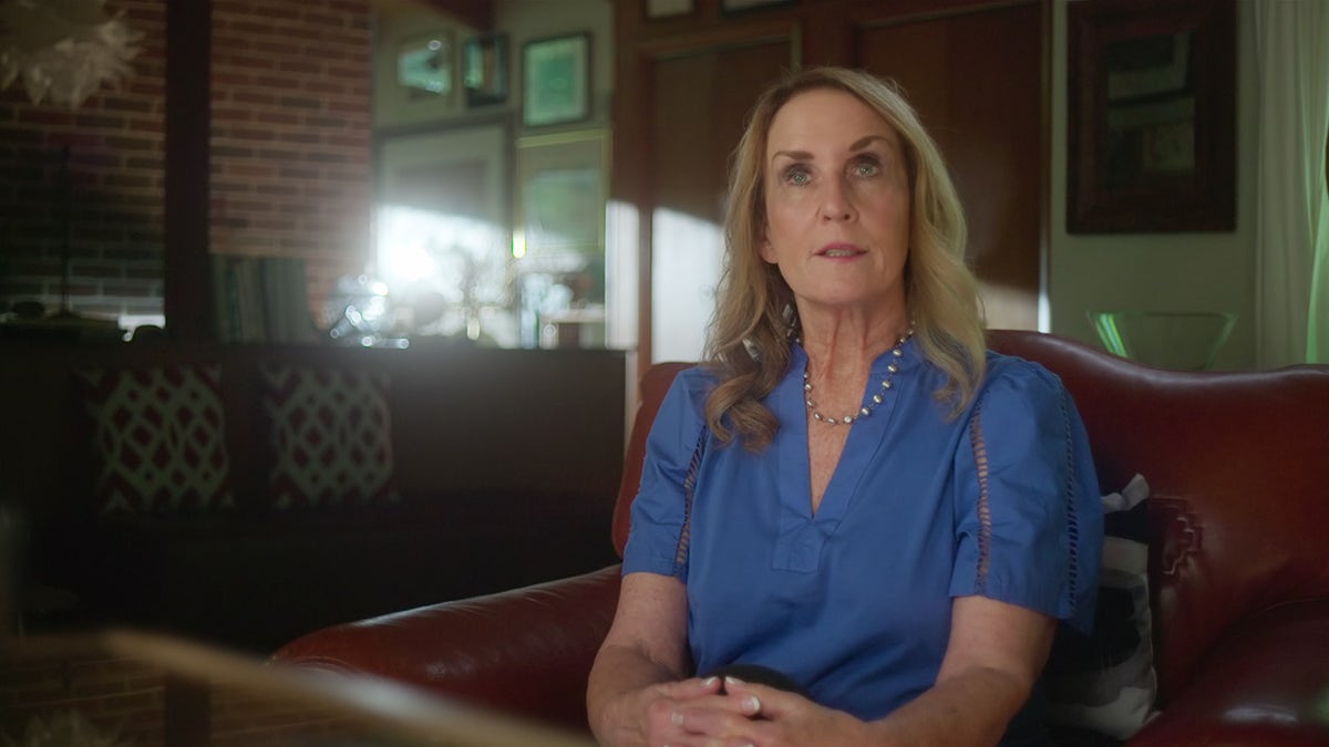 Judy Maurer draagt een blauwe blouse.