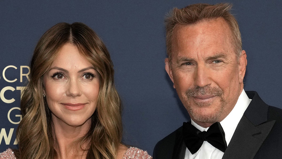 Kevin Costner en Christine Baumgartner lopen over rode loper