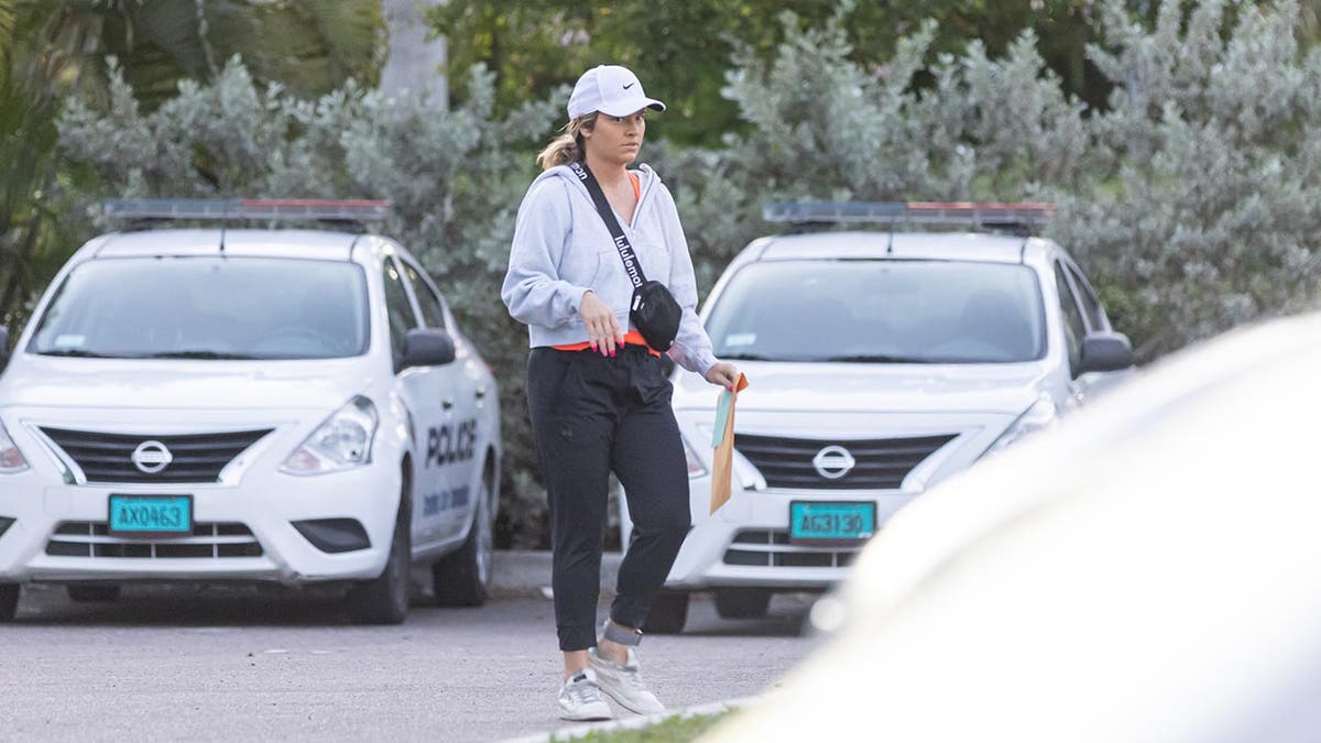 Lindsay Shiver in trainingspak loopt door een parkeergarage met een manillamap in de hand