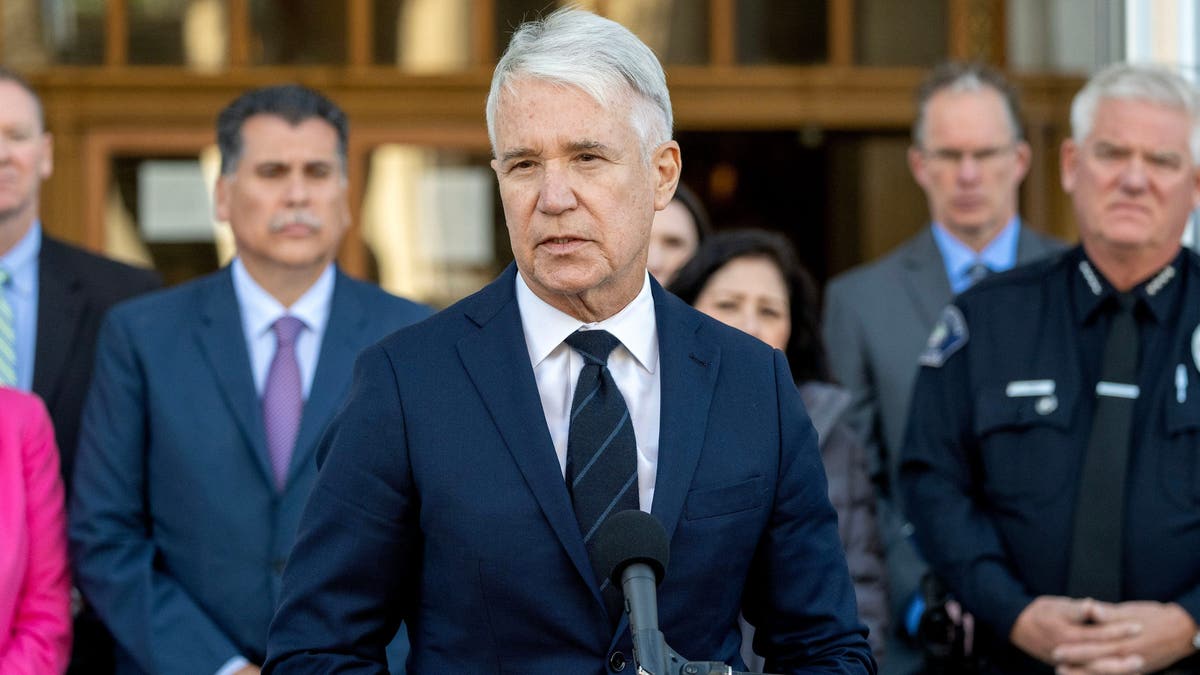 Openbaar aanklager George Gascon spreekt de media toe in marineblauw pak en donkere stropdas