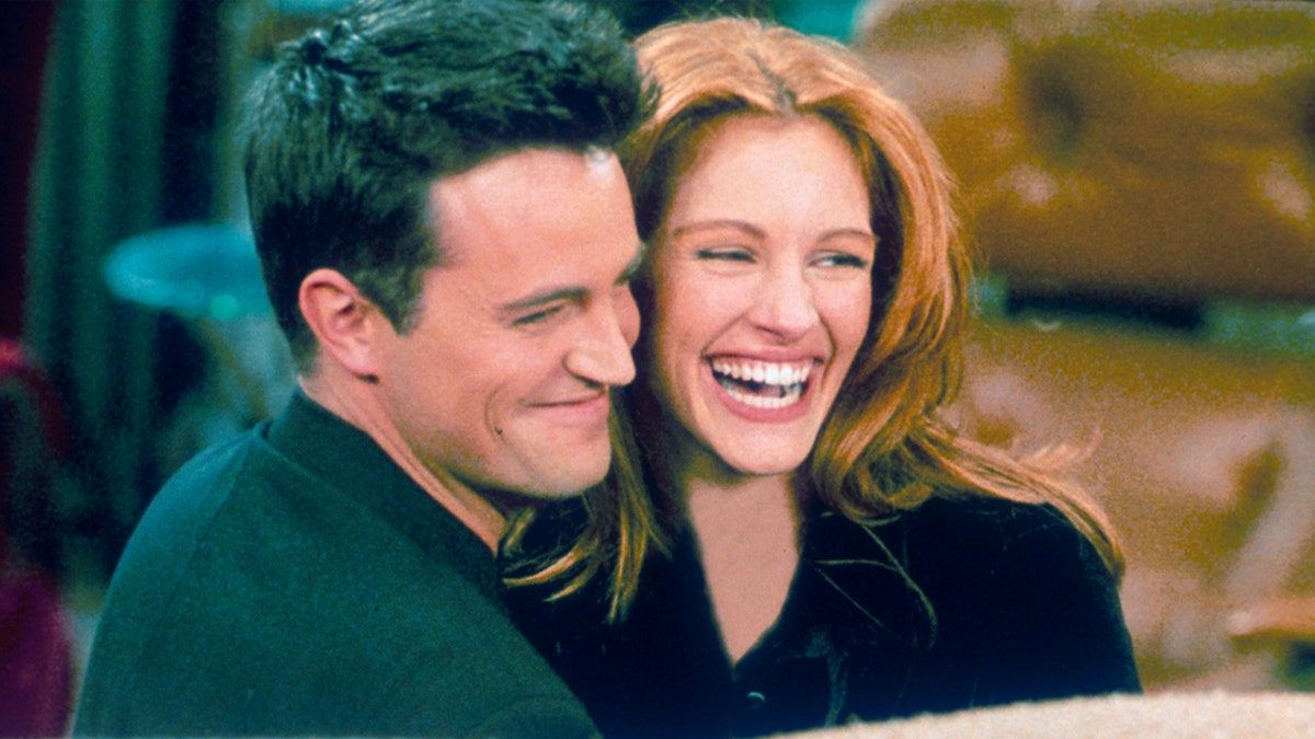 Matthew Perry als Chandler op de set van "Friends" omhelst actrice Julia Roberts