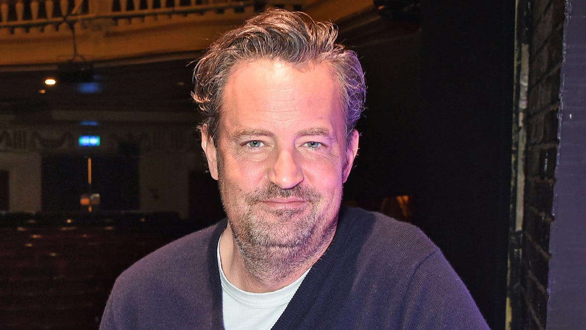 Matthew Perry draagt blauwe trui en t-shirt op evenement