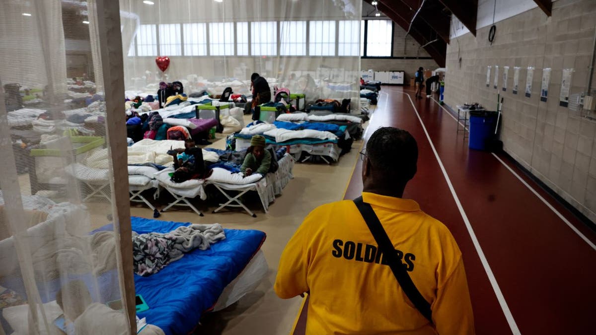 Meshach Little van Northill Wilkston Security Firm loopt langs de omtrek van de belangrijkste leefruimte in de nieuwe noodopvang voor migranten in het Melnea A. Cass Recreational Complex.