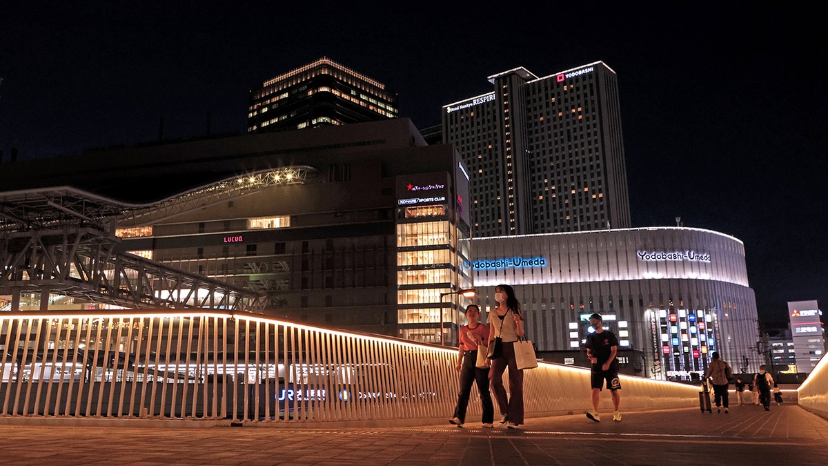 Voetgangers lopen op een loopbrug in Osaka, Japan.