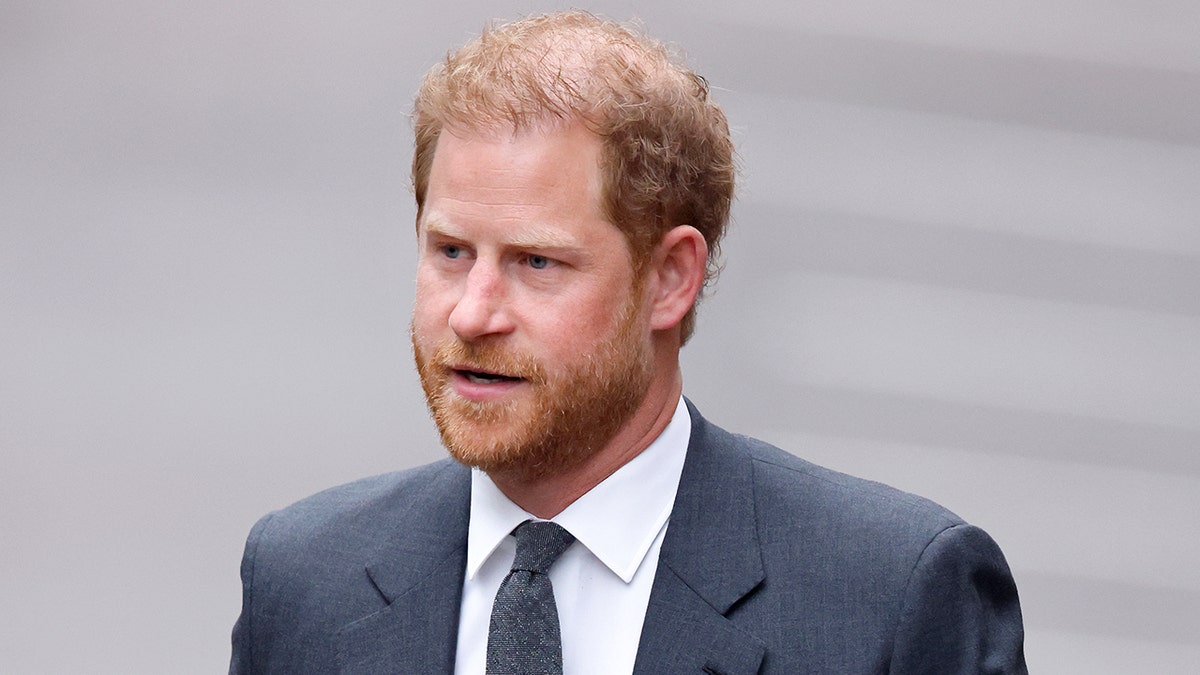 Prins Harry in een grijs pak en stropdas buiten in Londen