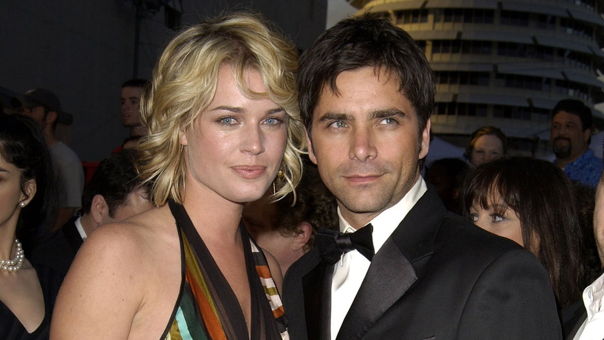 Rebecca Romijn loopt rode loper met John Stamos in smoking