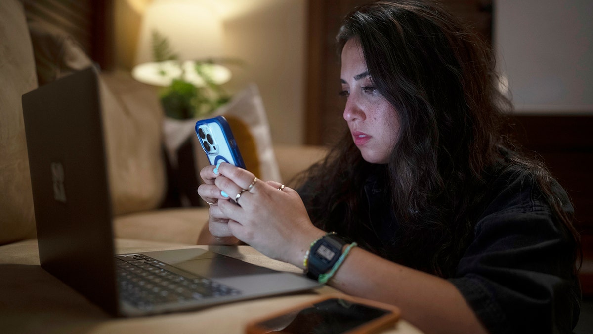 Roo Powell kijkt naar haar telefoon