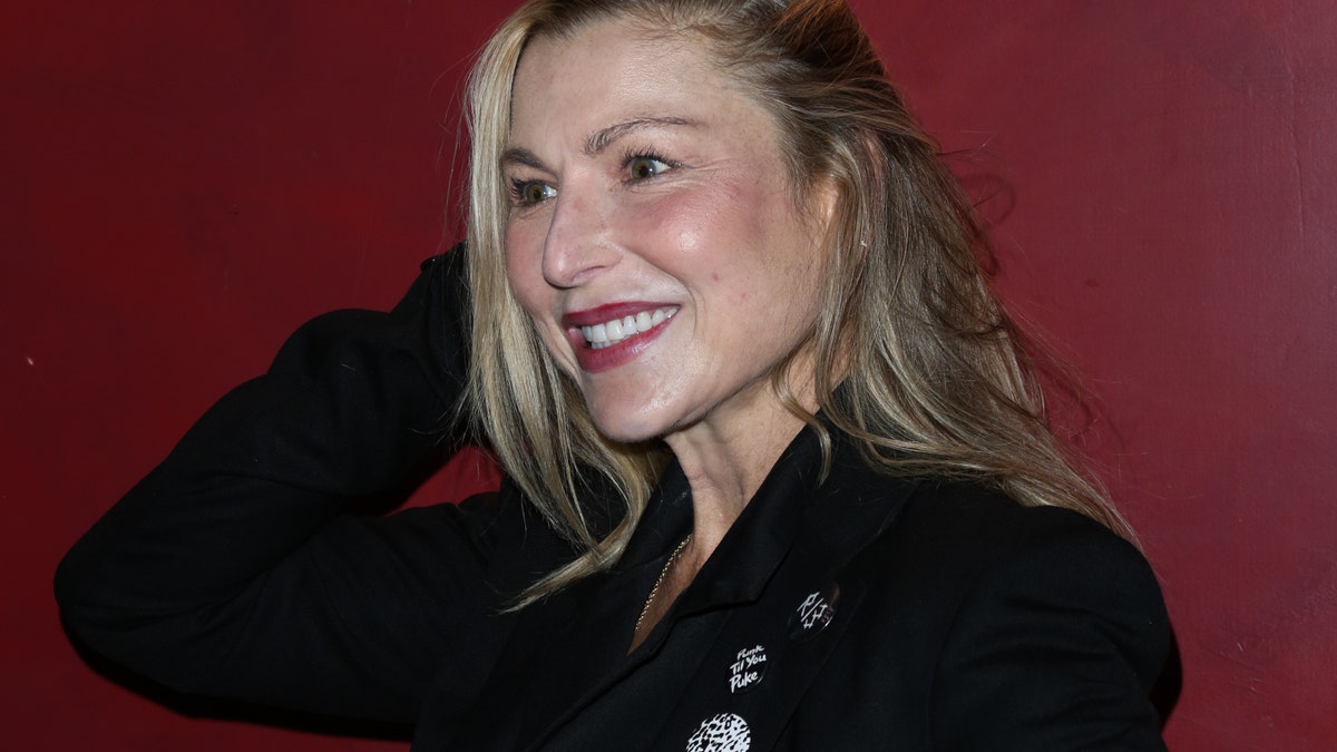 Tatum O'Neal in een zwart pak en glimlachend.