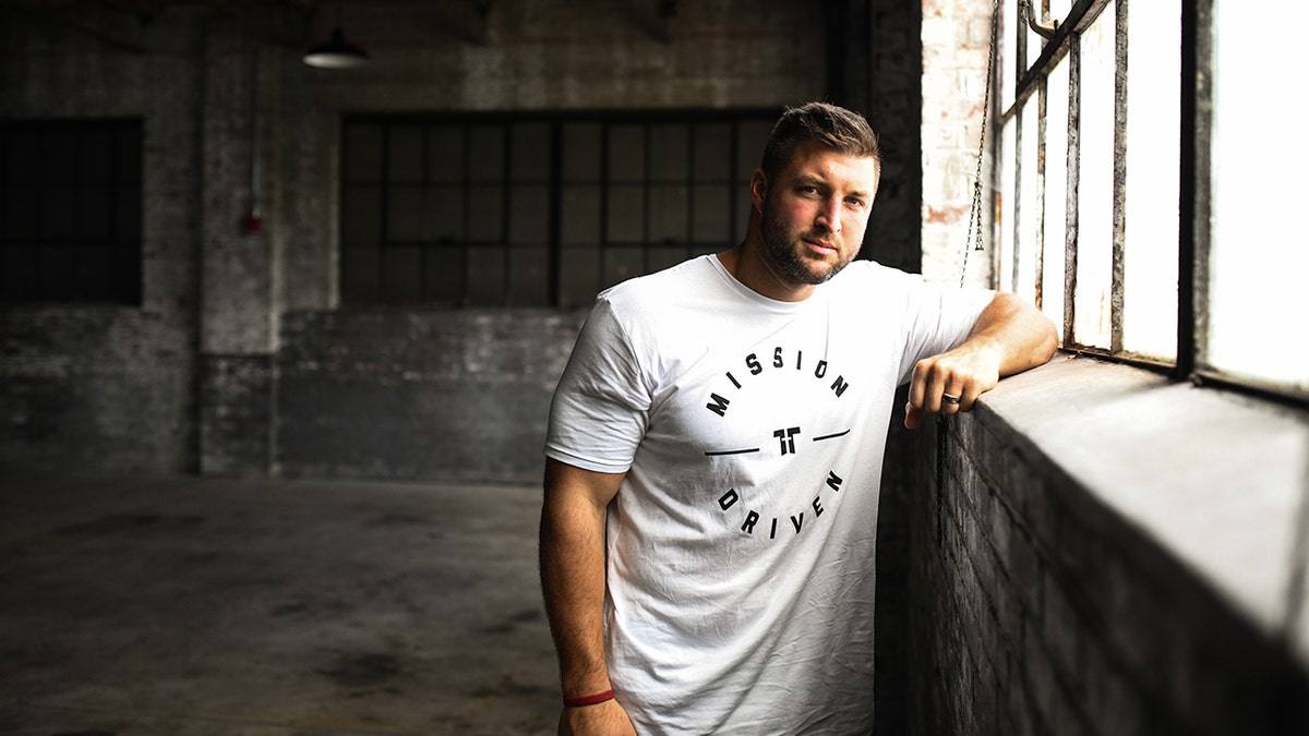 Tim Tebow draagt een "Mission Driven" T-shirt