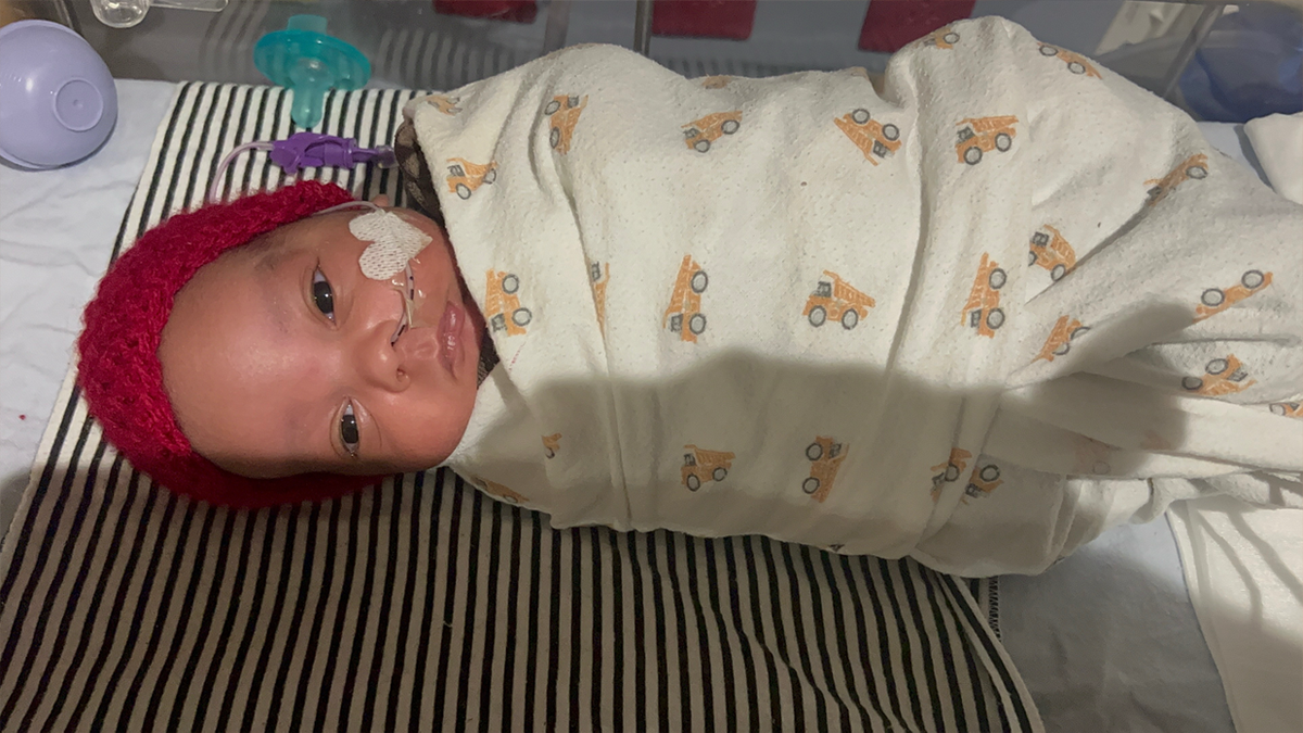 baby noah gewikkeld in een deken met een muts op