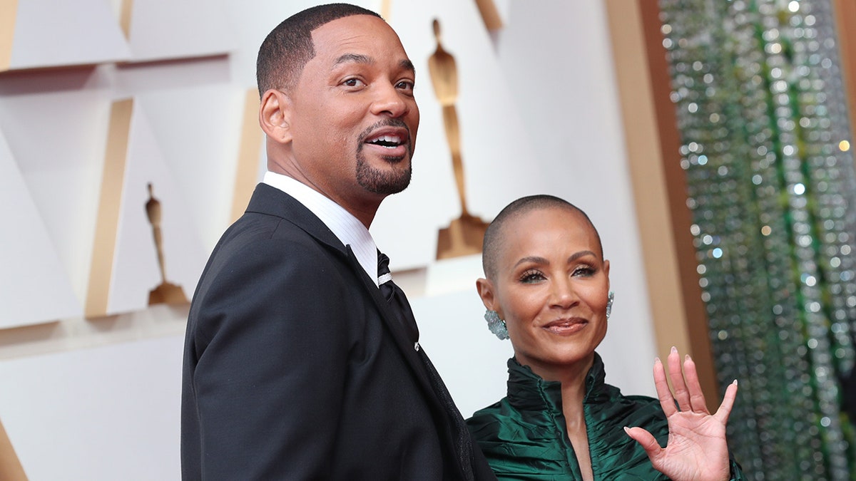 Will Smith ziet er een beetje opgedirkt uit op het tapijt bij de Oscars met Jada Pinkett Smith lachend naast hem in een groene jurk