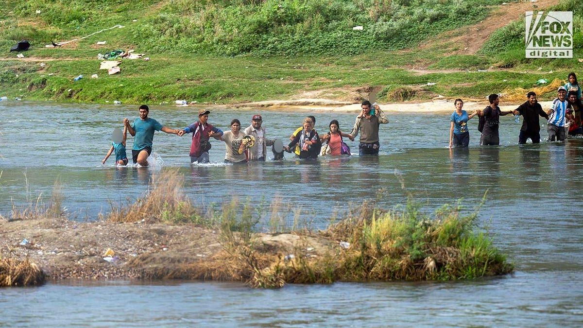 Een groep migranten, sommigen met kinderen, steekt op 27 september 2023 de Rio Grande rivier over in Eagle Pass, Texas. Het oversteken van de grens via Eagle Pass blijft een zware last voor de wetshandhavers, aangezien er dagelijks een ongekend aantal migranten de Verenigde Staten binnenkomt.